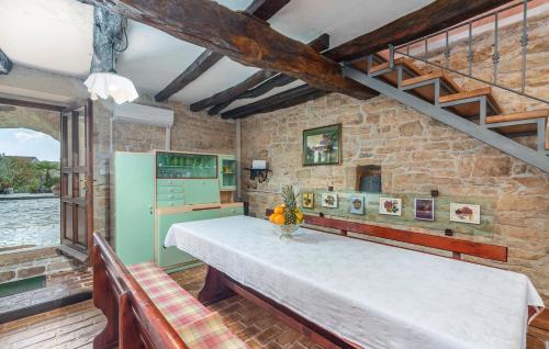 a kitchen with a white table and a brick wall at House Peresiji in Peresiji