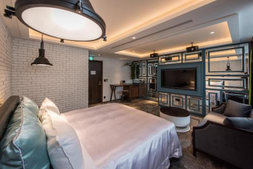 a bedroom with a bed and a flat screen tv at Green Palm Motel in Yuanlin