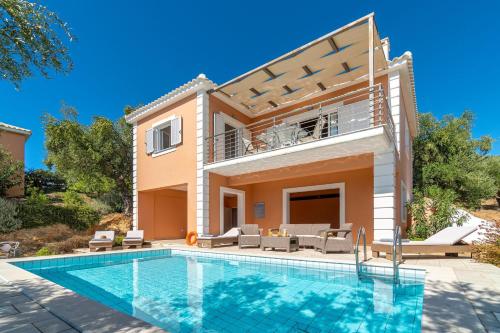 a villa with a swimming pool and a house at Schiza Houses in Finikounta