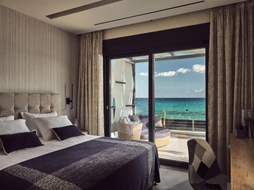 a bedroom with a bed and a view of the ocean at Blue View Villa - Coastal Elegance with Swim Spa, by ZanteWize in Alikanas