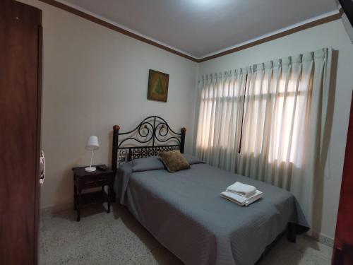 1 dormitorio con cama y ventana en departamento céntrico y confortable, en Tarija