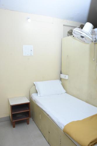 a small room with two beds and a night stand at Hotel Surya Residency Majestic in Bengaluru
