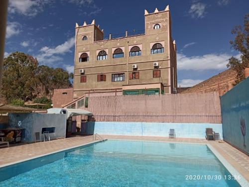 un bâtiment avec une piscine en face d'un bâtiment dans l'établissement Auberge Restaurant le Safran Taliouine, à Taliouine