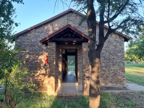 a brick building with a pathway leading into it at El Rancho Grande in Warmbaths