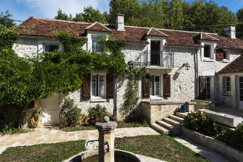 Uma casa de tijolos brancos com uma boca de incêndio à frente. em Le Riad Bourguignon em Ouanne