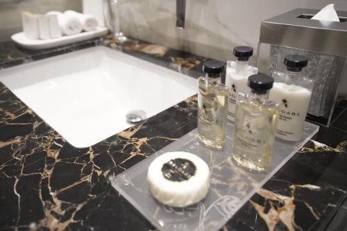 a bathroom counter with two bottles of perfume and a doughnut at Vivienda Hotel Villas, Jeddah in Jeddah