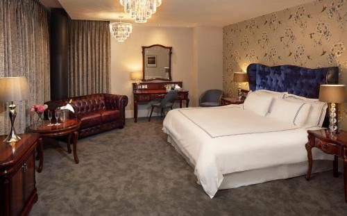 a bedroom with a king sized bed and a living room at Green Isle Hotel, Dublin in Clondalkin 