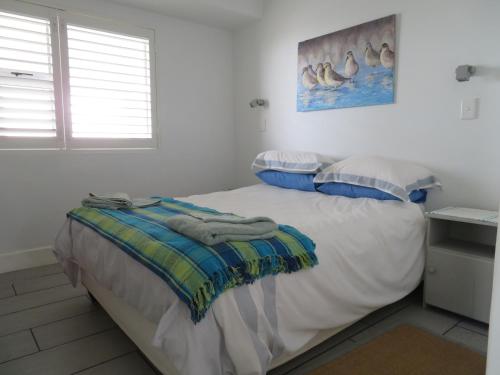 - une chambre avec un lit et des serviettes dans l'établissement 87 Marine Drive, à Struisbaai