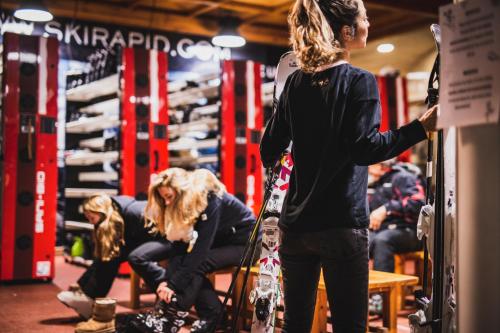 a woman is holding a snowboard in a store at Sport Hotel Village in Soldeu