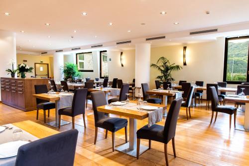 リヴィゾンドリにあるAqua Montis Resort & Spaのテーブルと椅子が備わるレストラン