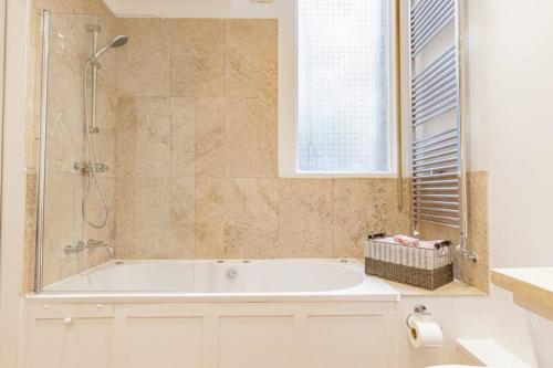 a bathroom with a bath tub and a shower at Oxfordshire Living - The Palin Apartment - Oxford in Oxford