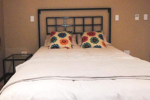 a large white bed with two pillows on it at Koemi in Kempton Park