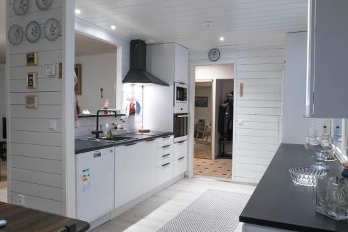 a kitchen with white cabinets and a black counter top at Talo-Villa- 3 mh+s - Kittilä - Levi upea keittiö in Kittilä