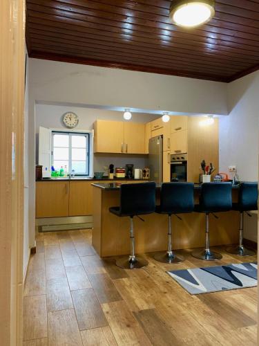 a kitchen with two bar stools and a counter at Casa Avô São Miguel in Angra do Heroísmo