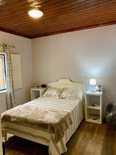a bedroom with a bed and two night stands at Casa Avô São Miguel in Angra do Heroísmo