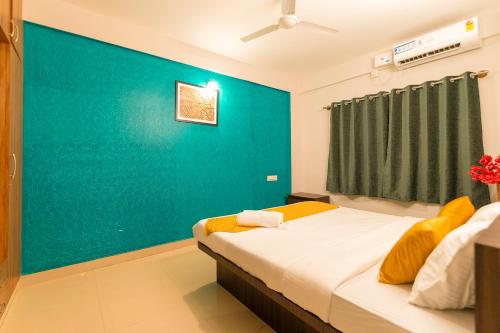 a room with a bed with a blue wall at High Q Suites in Bangalore