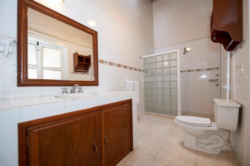 a bathroom with a toilet and a sink and a mirror at Hotel Senorial in Querétaro