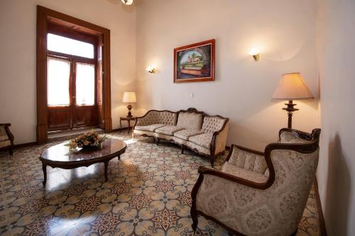 a living room with a couch and a table at Hotel Senorial in Querétaro