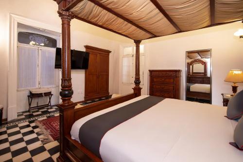 a bedroom with a large bed and a television at Hotel Senorial in Querétaro