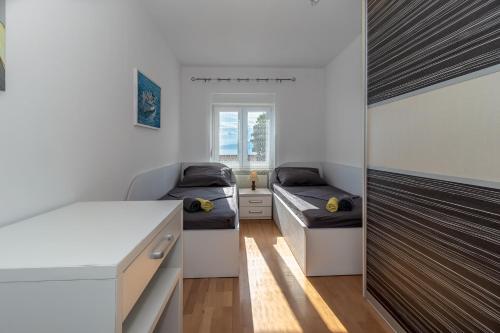 Habitación con 2 camas y escritorio. en Apartments Školjka, en Rijeka
