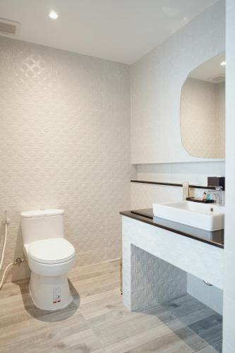 a bathroom with a white toilet and a sink at The Cotton Tree Hometel in Khon Kaen