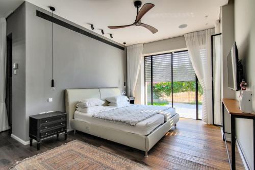 een slaapkamer met een bed en een plafondventilator bij Villa Zohara in Caesarea