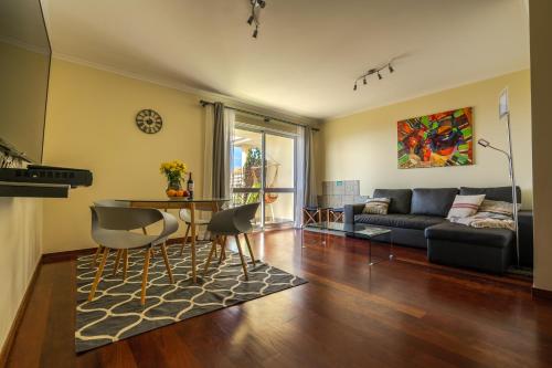 a living room with a couch and a table at Ocean Breeze in Caniço