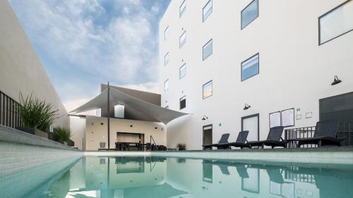 a building with a swimming pool in front of a building at Staybridge Suites - Villahermosa Tabasco by IHG in Villahermosa