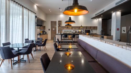a restaurant with tables and chairs and a bar at Staybridge Suites - Villahermosa Tabasco by IHG in Villahermosa