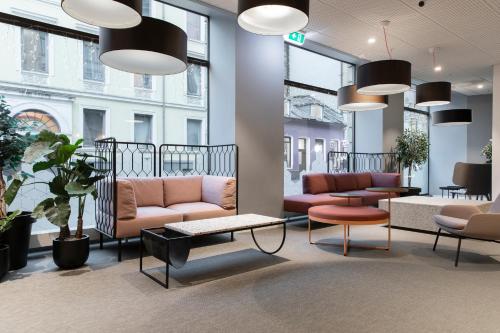 a waiting room with couches and tables and windows at Citybox Oslo in Oslo
