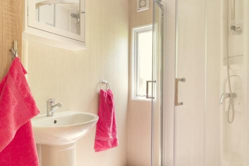 baño con toallas rosas y lavamanos en Mobile Home 4p en Zuna