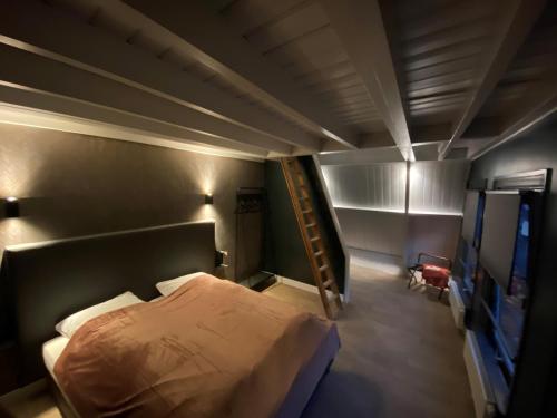 Un dormitorio con una cama y una escalera. en OP10 Logeren, en Oldenzaal