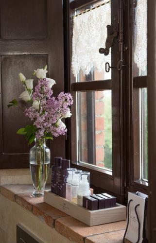 a vase of flowers sitting on a counter next to a window at Agriturismo Cretaiole in Pienza