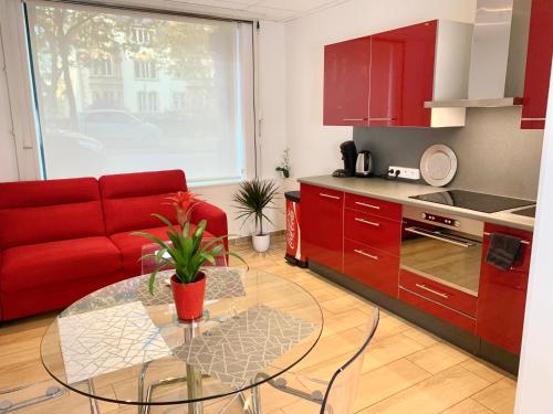 - un salon avec un canapé rouge et une table en verre dans l'établissement Appart' Weekly Quartier Impérial Gare, à Metz