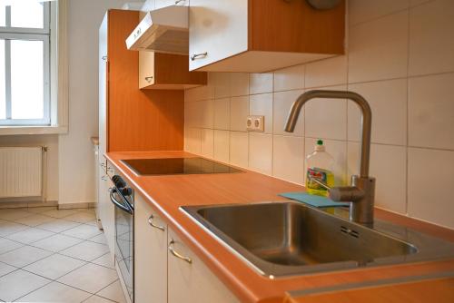 cocina con fregadero y encimera en Highlight Suite Augarten, en Viena