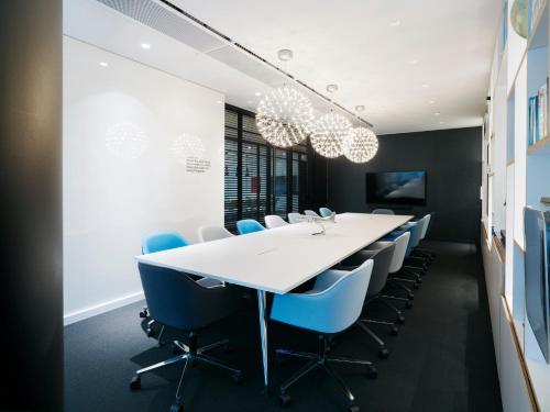 a conference room with a white table and blue chairs at citizenM Washington DC Capitol in Washington