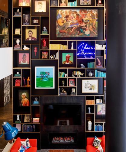 a living room with a fireplace and a wall of pictures at citizenM Washington DC Capitol in Washington