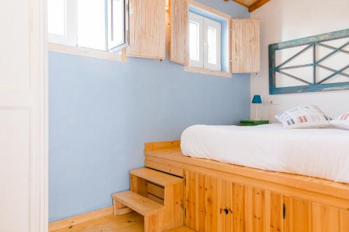 a bedroom with a bed and wooden cabinets at Quinta das Alfazemas in Ericeira