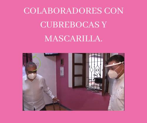 two people wearing masks standing in a room at Hotel del Marquesado in Oaxaca City