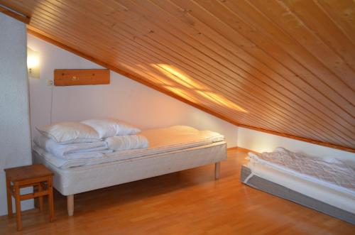 a bed in a room with a wooden ceiling at Castillo Vuorsa 3 in Saariselka