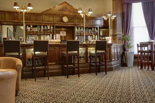 - un bar avec des chaises et un comptoir dans une pièce dans l'établissement Burnley North Oaks Hotel and Leisure Club, à Burnley