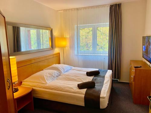 een hotelkamer met een bed en een televisie bij Słupsk forest PREMIUM HOTEL APARTAMENT M6 - Kaszubska street 18 - Wifi Netflix Smart TV50 - two bedrooms two extra large double beds - up to 6 people full - pleasure quality stay in Słupsk