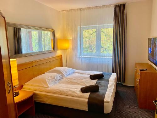 a hotel room with a bed and a television at Słupsk forest PREMIUM HOTEL APARTAMENT M6 - Kaszubska street 18 - Wifi Netflix Smart TV50 - two bedrooms two extra large double beds - up to 6 people full - pleasure quality stay in Słupsk