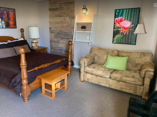 a bedroom with a bed and a couch at Le Loft Riverstone in Saint Pierre de Broughton