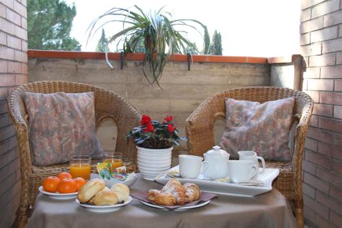a table with a breakfast of croissants and orange juice at Hotel I Platani in Siena