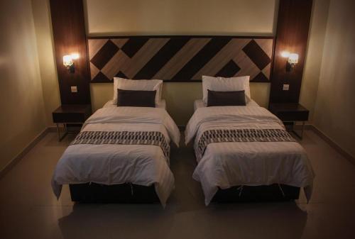 two beds sitting next to each other in a room at ليالي ألماسية للشقق المخدومة Layali Almasiah serviced apartment in Al Muzāḩimīyah