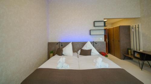 a bedroom with a large bed with white shoes on it at Grand Hotel BELLEVUE in Smokovce