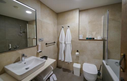 
a bathroom with a toilet, sink and bathtub at Grand Hotel BELLEVUE in Vysoké Tatry

