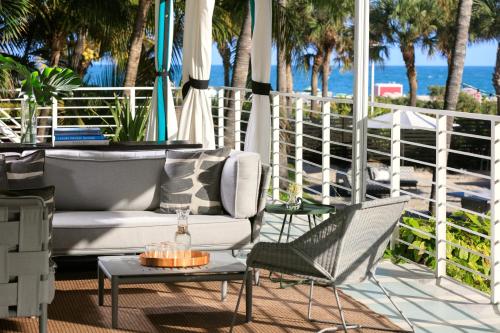 a patio with a couch and chairs and the beach at Kimpton Surfcomber Hotel, an IHG Hotel in Miami Beach