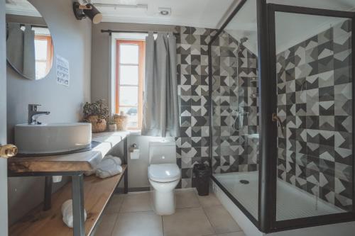 a bathroom with a sink and a toilet and a shower at Selina Plaza Pucón in Pucón